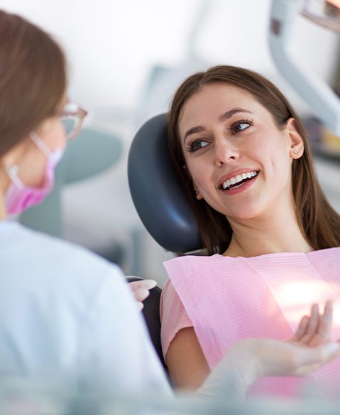 Woman smiling at dental team member