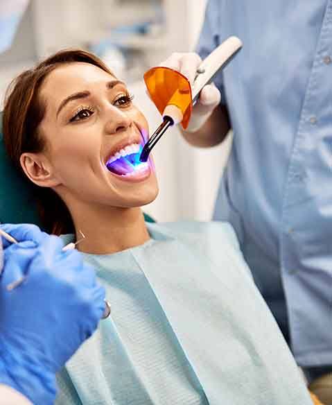 patient getting cosmetic dental bonding with the curing light