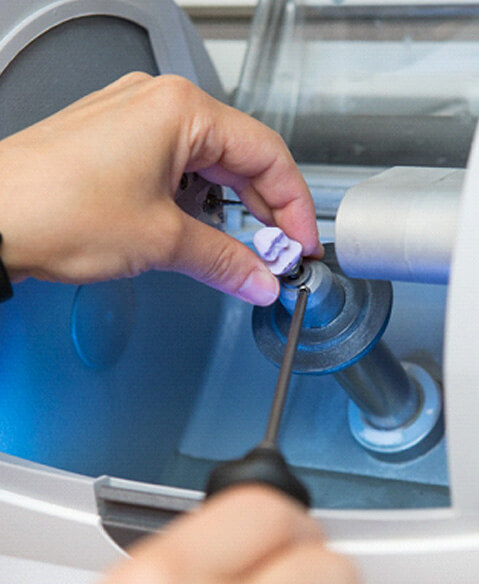 hand reaching into a milling machine with a crown