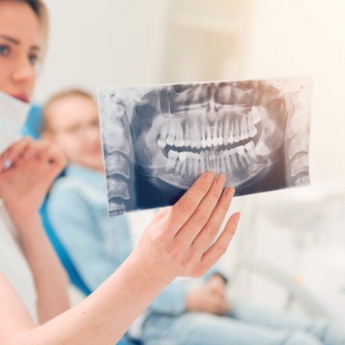 Dentist holding up an X-ray for patient to see