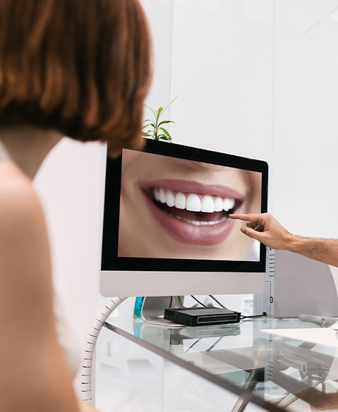 Dentist and patient reviewing smile makeover design on computer screen