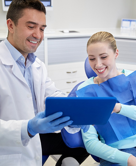 patient and dentist talking about cost of cosmetic dentistry with a tablet