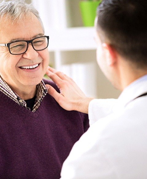 Man with dentures in Fayetteville smiling at his dentist