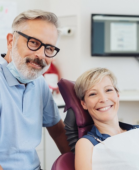 Woman with dentures in Fayetteville smiling in dentist's office