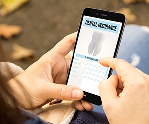 Dental patient checking dental insurance information on phone