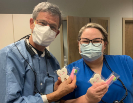 Doctor Lee and dental team member holding patient gifts