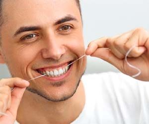 Man flossing to avoid dental emergencies in Fayetteville