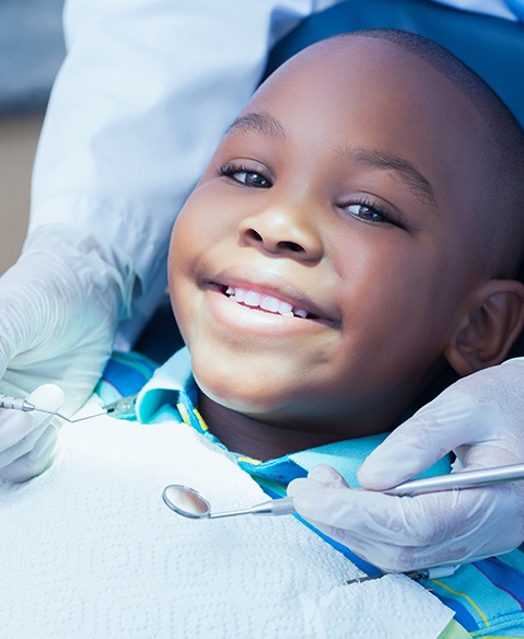 Child smiling after dental sealant placement