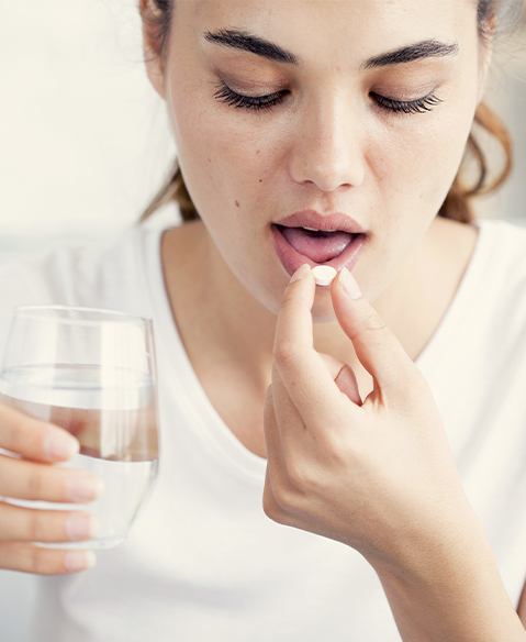 Woman taking oral conscious dental sedation pill