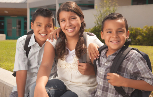 Three children sharing healthy smiles after family dentistry treatment