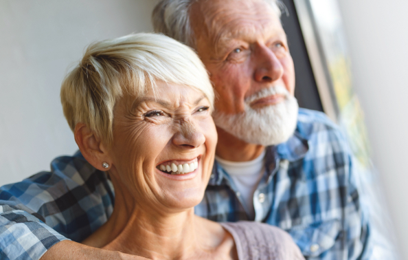 Man and woman with healthy smiles after dental implant tooth replacement