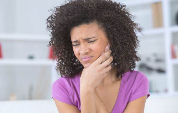 Woman in need of emergency dentistry holding jaw in pain