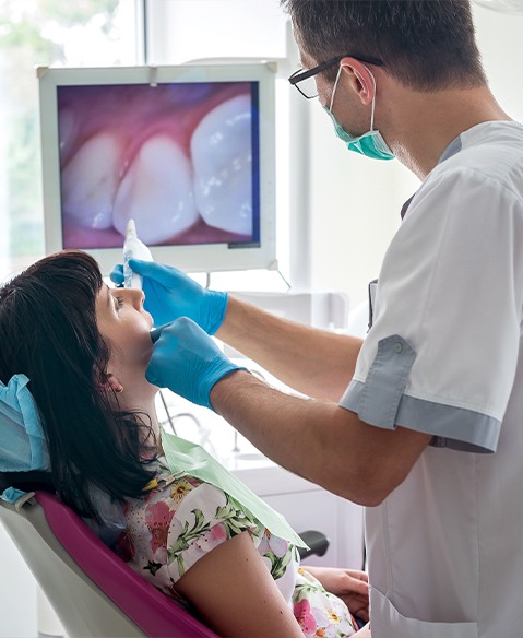 Dentist using intraoral camera to examine patient's smile