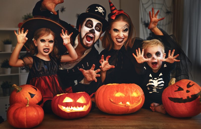 A family enjoying showing off their Halloween smiles in spooky costumes