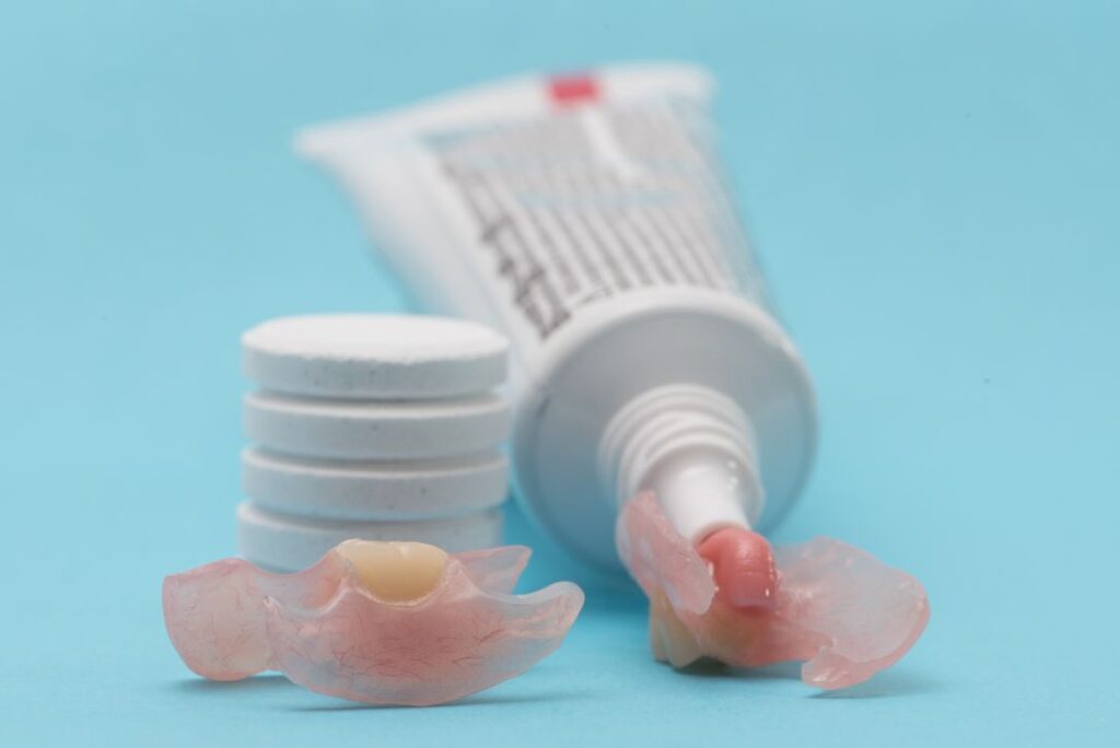Dentures and a tube of denture adhesive